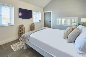 1 dormitorio con 1 cama blanca grande y TV en Host & Stay - The Stables en Yarm