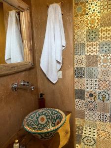 a bathroom with a toilet and a sink and a mirror at Bin Jbal Resort in Ouirgane