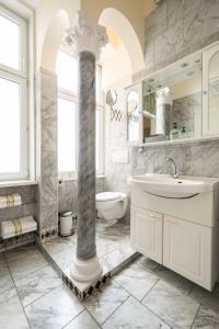 ein Badezimmer mit einer Säule, einem Waschbecken und einem WC in der Unterkunft Pension Primavera in Wien