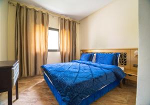 a bedroom with a blue bed and a window at Résidence Hôtelière Le Diamant Vert in Fez