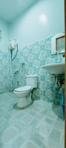 a bathroom with a toilet and a sink at Genna's Tourist Inn Santa Fe in Bantayan Island