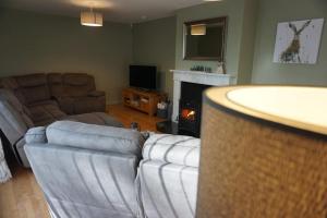 a living room with a couch and a living room with a fireplace at Rarooey House in Donegal