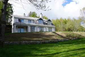 uma casa branca no topo de uma colina relvada em Rarooey House em Donegal