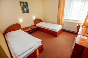 a small room with two beds and a window at Hotel Boss in Žilina