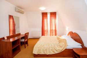 a bedroom with a bed and a desk and a desk at Hotel Boss in Žilina