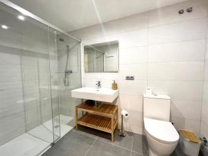a bathroom with a toilet and a sink and a shower at Espot Cowork & Apartments in Espot