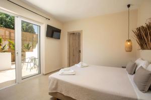 1 dormitorio con 1 cama y puerta corredera de cristal en Atma Beach Rooms & Suites en Faliraki