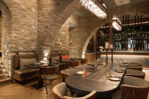a restaurant with a large wooden table and chairs at Castro Hotel Syros in Ermoupoli