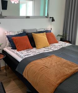 Bett mit bunten Kissen auf einem Zimmer in der Unterkunft StarHomes Studio Lux 10 in Oulu