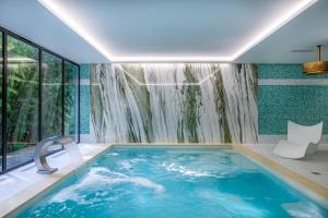 a bathroom with a plunge pool with a waterfall at Château des Reynats in Chancelade