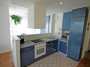 eine Küche mit blauen und weißen Schränken und einem Waschbecken in der Unterkunft Ferienwohnung "Albrecht der Seebär" in Kühlungsborn