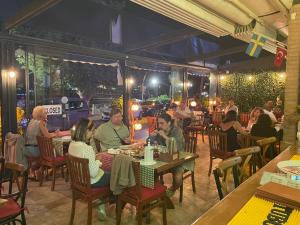a group of people sitting at tables in a restaurant at Queen Victoria Suit Apart OTEL in Bodrum City