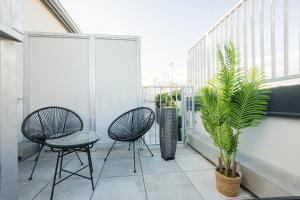 balkon z 2 krzesłami, stołem i rośliną w obiekcie OrestaLiving - Penthouse with designer renovation w Wiedniu