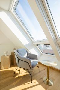 - une lucarne dans une chambre avec une chaise et une table dans l'établissement OrestaLiving - Penthouse with designer renovation, à Vienne