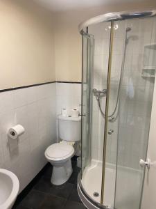 a bathroom with a toilet and a glass shower at OYO Gran Canaria Hotel in Folkestone