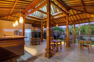 a large wooden pavilion with tables and chairs at Pondooks Joglo in Nusa Lembongan