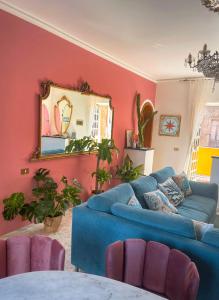 a living room with a blue couch and a mirror at Follow The Sun Catania - Rooftop Terrace in Catania