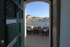 una puerta abierta con mesa, sillas y agua en FLH Porto Ribeira with River View en Oporto