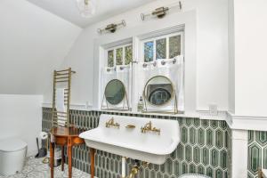 Metaline FallsにあるThe Rock House of Metaline Fallsの洗面台と2つの鏡があるバスルーム