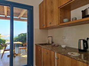 kuchnia z drewnianymi szafkami i widokiem na ocean w obiekcie Tilos Villa w mieście Livadia +37 zdjęć