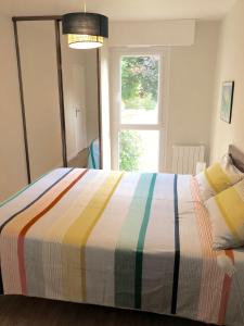 a bedroom with a colorful bed with a window at Résidence Brocéliande in Saint Malo