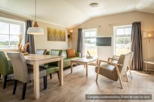 a dining room and living room with a table and chairs at Camping Loodsmansduin in Den Hoorn