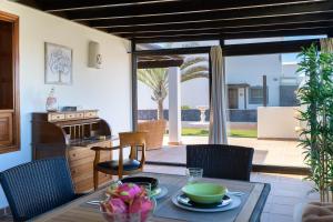kuchnia i salon ze stołem i krzesłami w obiekcie Hipoclub Villas, Aguamarina 1 w mieście Playa Blanca
