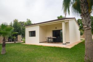 una pequeña casa blanca con una mesa en un patio en Résidence Hôtelière Le Diamant Vert en Fez