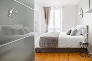 a white bedroom with a bed and a window at L'Authentik, charme et confort en vieille ville in Annecy