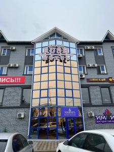 a tall building with a sign on top of it at Rush Hotel in Atyraū