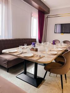 a large wooden table in a room with a couch at Rush Hotel in Atyraū