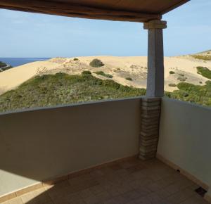 a balcony with a view of the sand dunes at Mare, dune, lago e bosco in assoluto relax. in Torre Dei Corsari