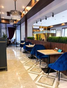 un restaurante con sillas y mesas azules en una habitación en Rush Hotel, en Atyraū