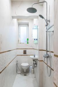 een witte badkamer met een toilet en een wastafel bij National Palace of Culture View - Spacious 1-BD Flat in Sofia