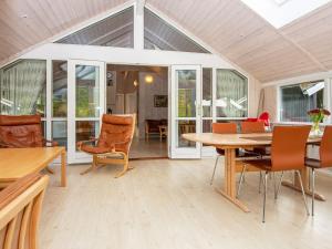 a conservatory with a table and chairs and a dining room at 8 person holiday home in Hovborg in Hovborg
