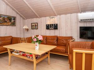 a living room with a couch and a table with flowers at 8 person holiday home in Hovborg in Hovborg