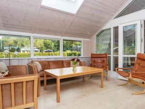 a screened in porch with a table and chairs at 8 person holiday home in Hovborg in Hovborg