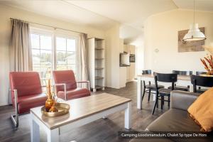 - un salon avec un canapé, une table et des chaises dans l'établissement Camping Loodsmansduin, à Den Hoorn
