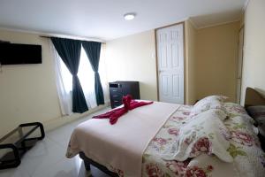 a bedroom with a bed with a pink ribbon on it at Hostal Beatriz Taltal in Taltal
