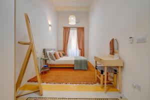 a small bedroom with a bed and a desk at Traditional Maltese Townhouse wt Terrace and Pool in Senglea