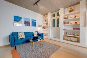 ein Wohnzimmer mit einem blauen Sofa und einem Tisch in der Unterkunft Traditional Maltese Townhouse wt Terrace and Pool in Senglea