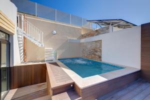 a swimming pool in the middle of a house at Traditional Maltese Townhouse wt Terrace and Pool in Senglea