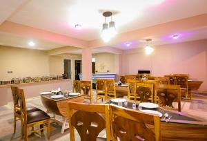 Smuggler Resort في مانالي: غرفة طعام مع طاولات وكراسي خشبية