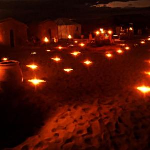 a group of lit candles in a street at night at desert Feeling in Mhamid