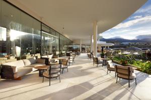 a patio with couches and chairs on a building at Hard Rock Hotel Tenerife in Adeje