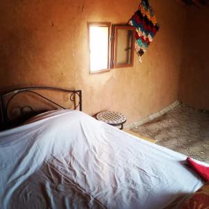 a bedroom with a bed and a window and a chair at desert Feeling in Mhamid