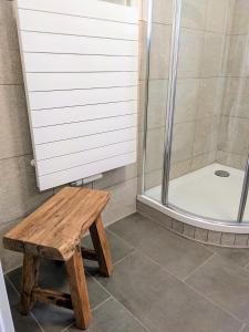 La salle de bains est pourvue d'un banc en bois et d'une douche. dans l'établissement Ferienwohnung BergOase, à Scheidegg