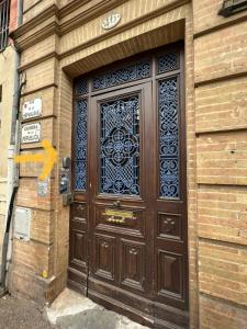 uma grande porta de madeira com uma janela num edifício em Toulouse : Studio équipé au cœur de St-Cyprien em Toulouse
