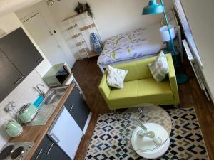 ロンドンにあるAccommodation HUB Studio 3のソファ、シンク、ベッドが備わる小さな客室です。