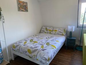 a small bedroom with a bed with a comforter at Accommodation HUB Studio 3 in London